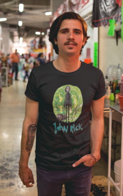 Man wearing a 'John Rick' t-shirt in a bustling indoor market.