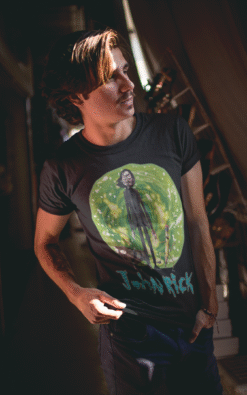 Young man sporting John Rick t-shirt with bold, colorful character design and text logo