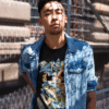 Urban streetwear look with Asian man wearing black Pokémon t-shirt featuring original starters and denim jacket
