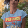 Curly-haired woman modeling Bulma Dragonball Pulp Fiction mashup t-shirt in an urban setting