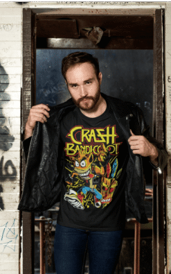 Close-up of a man showing off his black Crash Bandicoot vintage band t-shirt under a leather jacket.