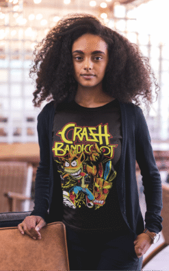 Woman in a black Crash Bandicoot retro graphic t-shirt relaxing indoors.