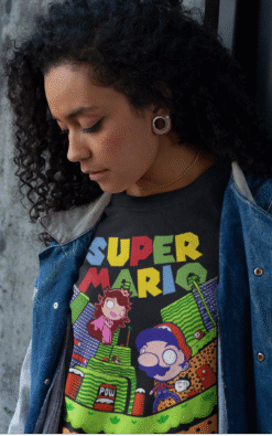 Close-up of woman with curly hair wearing black Super Mario t-shirt and denim jacket