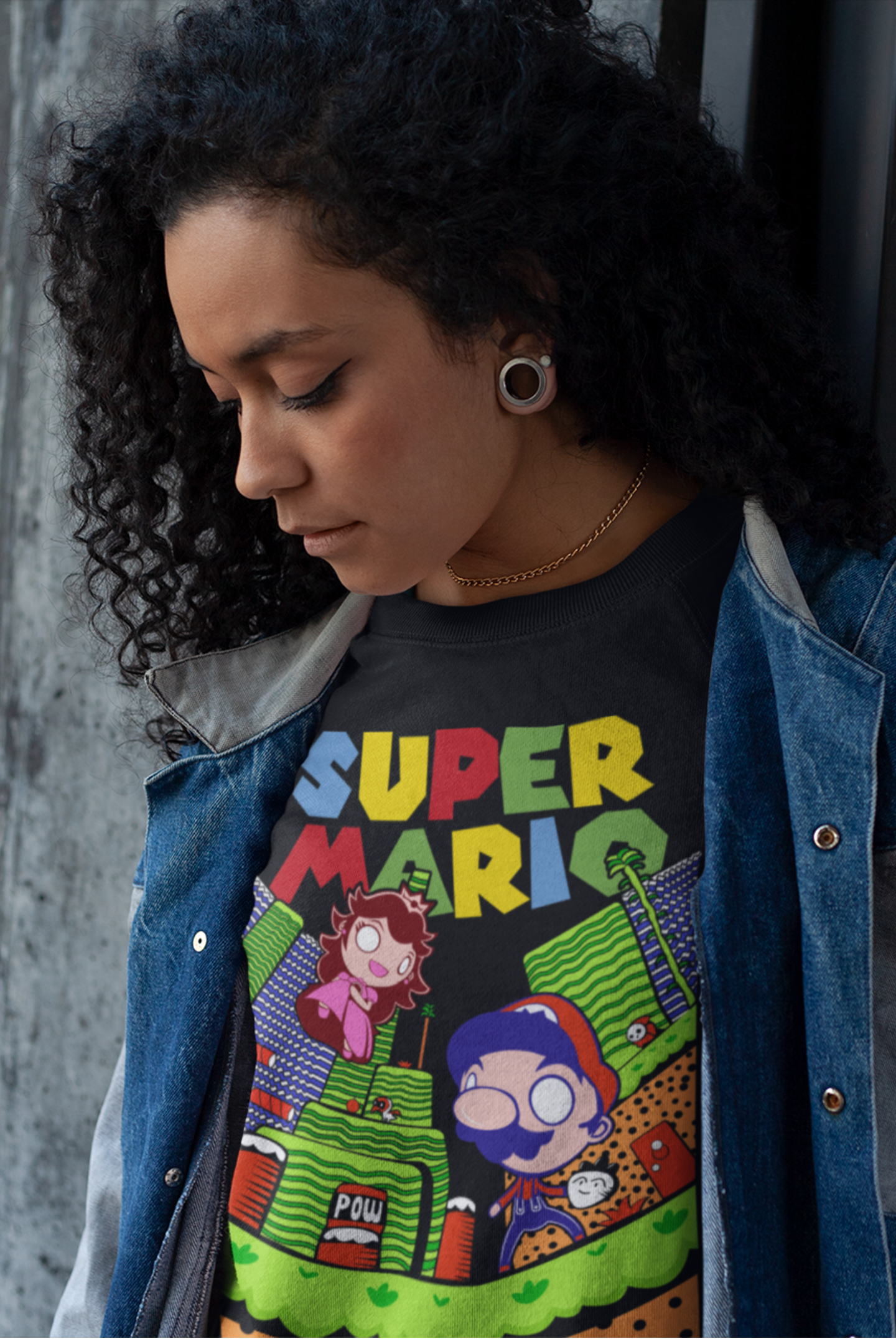 Close-up of woman with curly hair wearing black Super Mario t-shirt and denim jacket