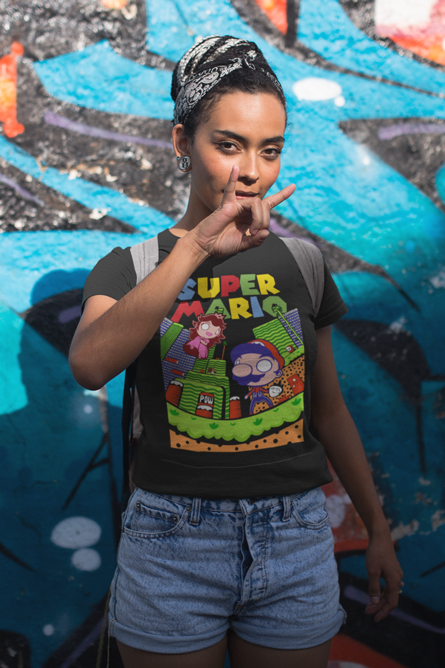 Woman posing in black Super Mario t-shirt against graffiti wall background