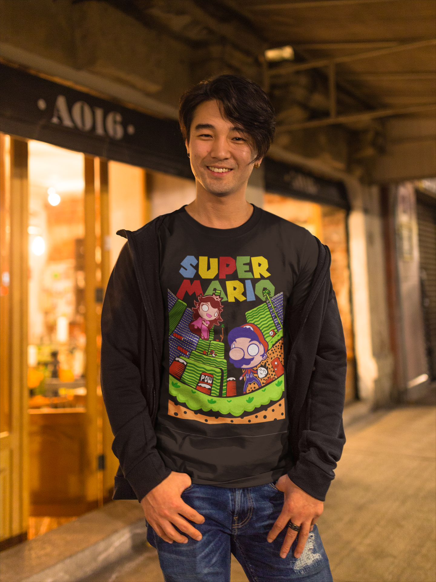 Happy Asian man wearing black Super Mario unisex t-shirt smiling on a city street at night