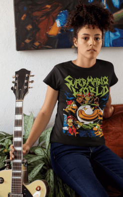 Woman leaning on couch wearing a Super Mario World heavy metal t-shirt holding a guitar.